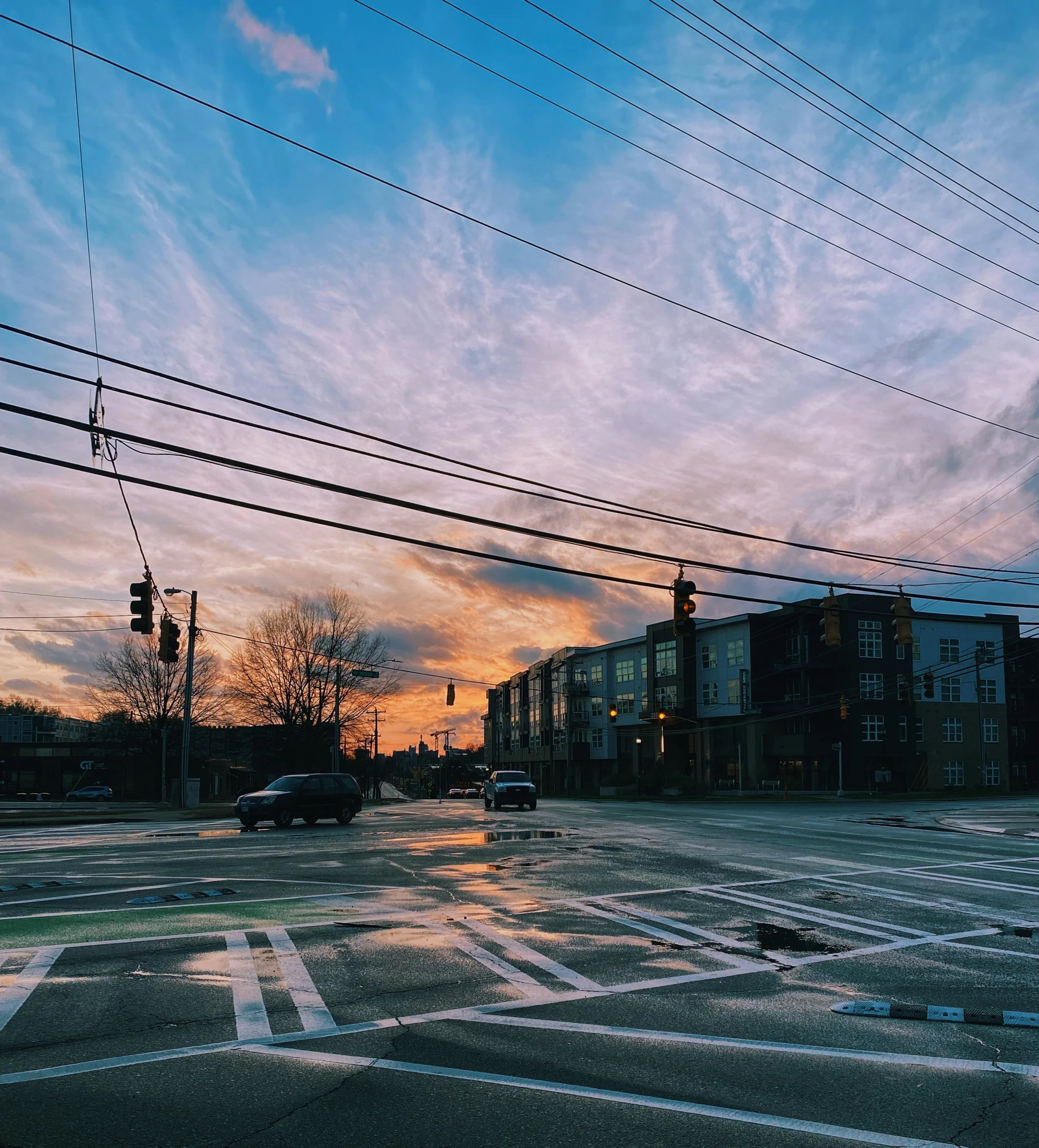 street lights and wires in an empty area at dusk