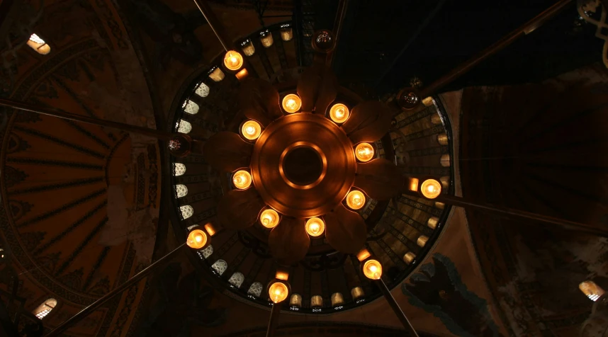 a light fixture with some candles lit in it