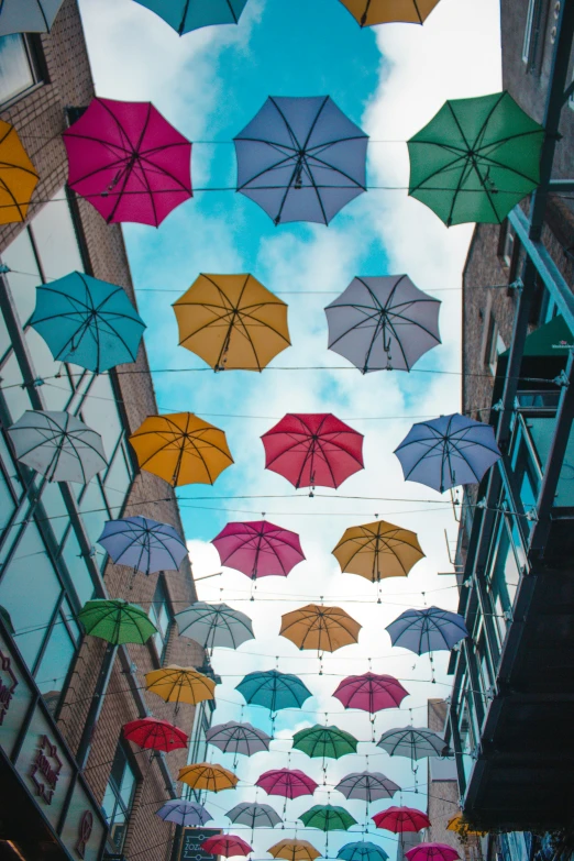 many different colored umbrellas in the air