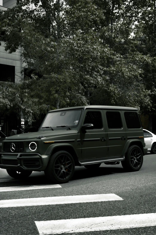 a green mercedes benz g class is parked