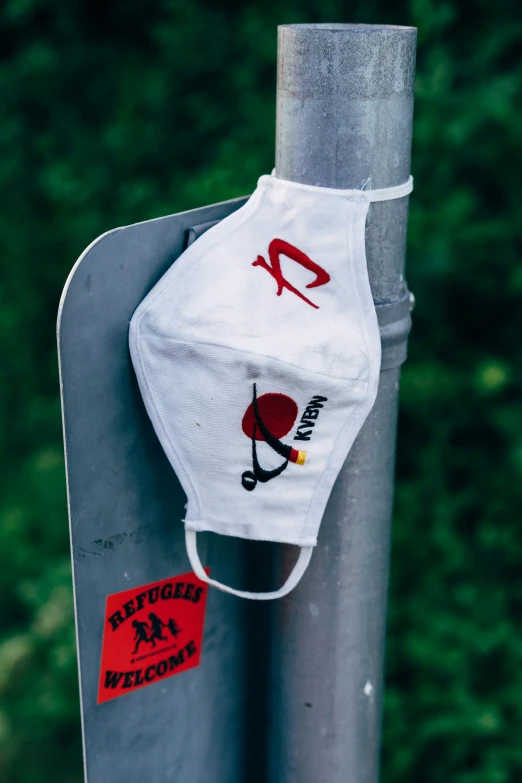 a mask hanging from the top of a pole