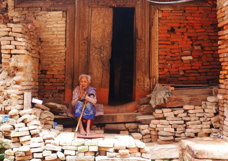 a woman is outside of a building with bricks on the front