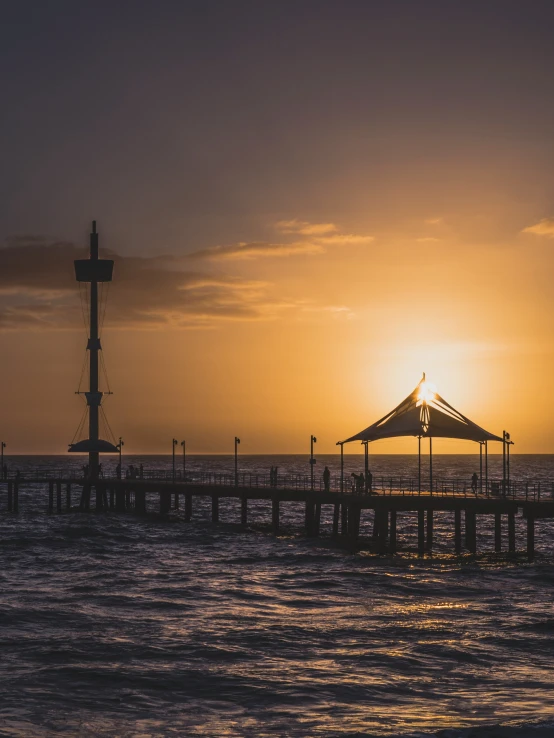 the sun shines on a pier over water