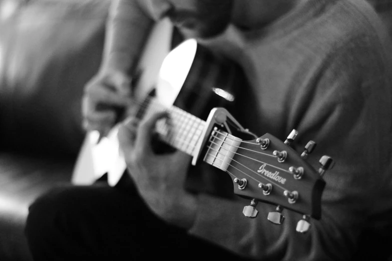 a man is playing the guitar and his eyes are closed