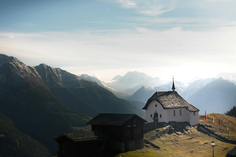 some white buildings on a mountain with some mountains behind them