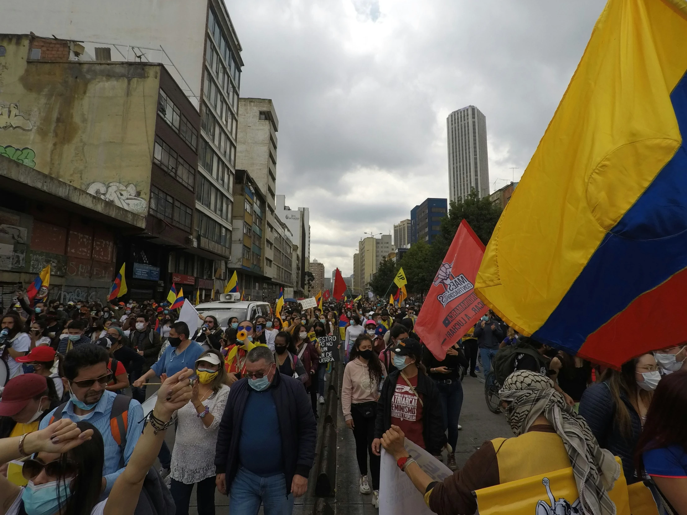 a group of people are protesting while one person is holding a large flag