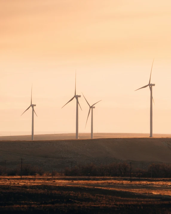 wind turbines are seen from across the field