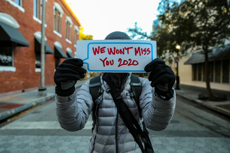 a person holding a sign with writing on it