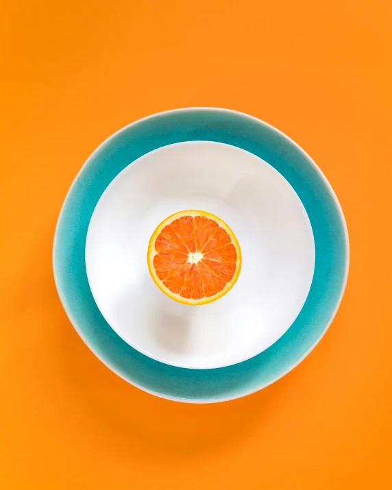 an orange sitting in a bowl on top of a table