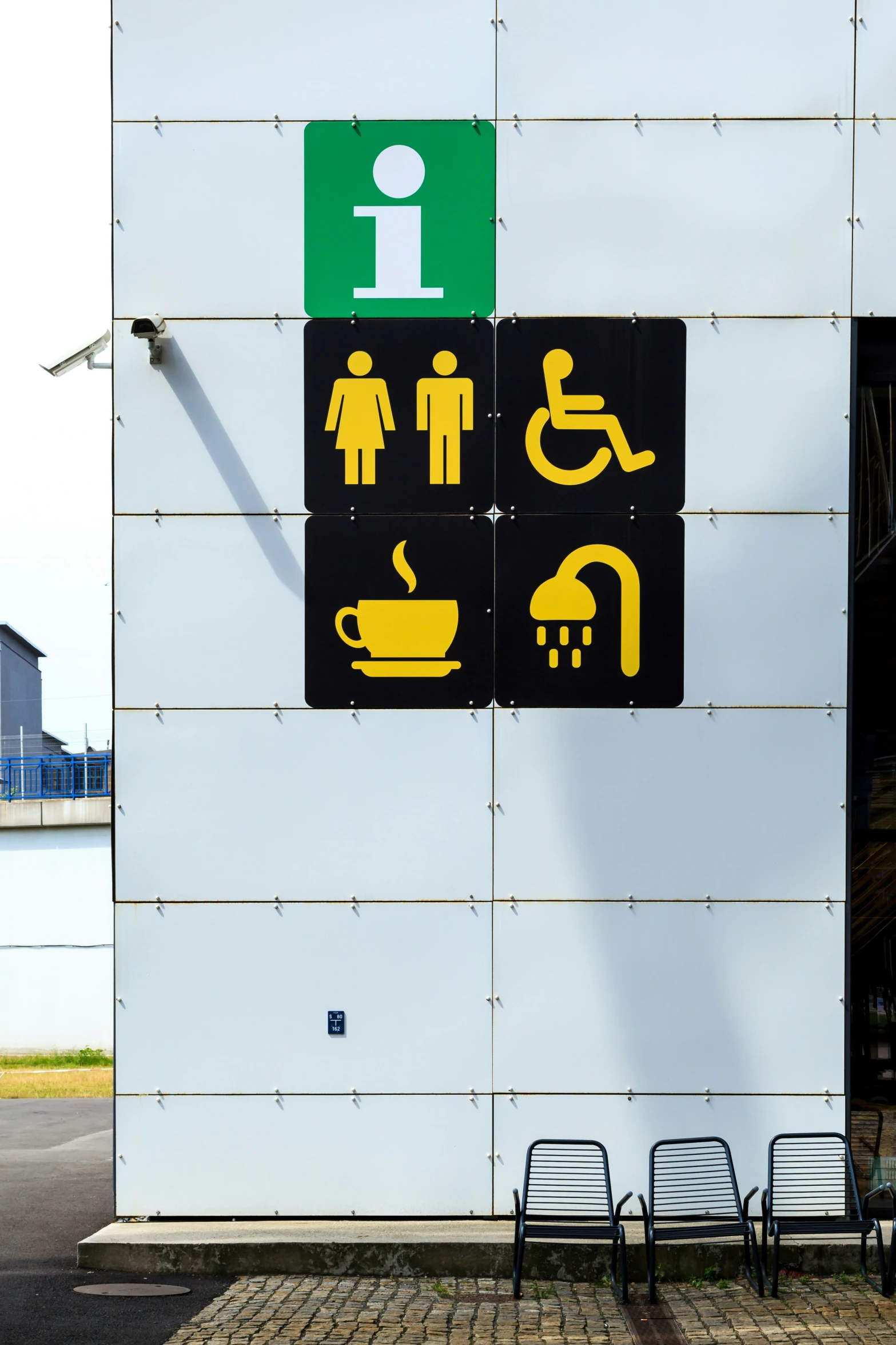 a toilet sign mounted to the side of a white wall