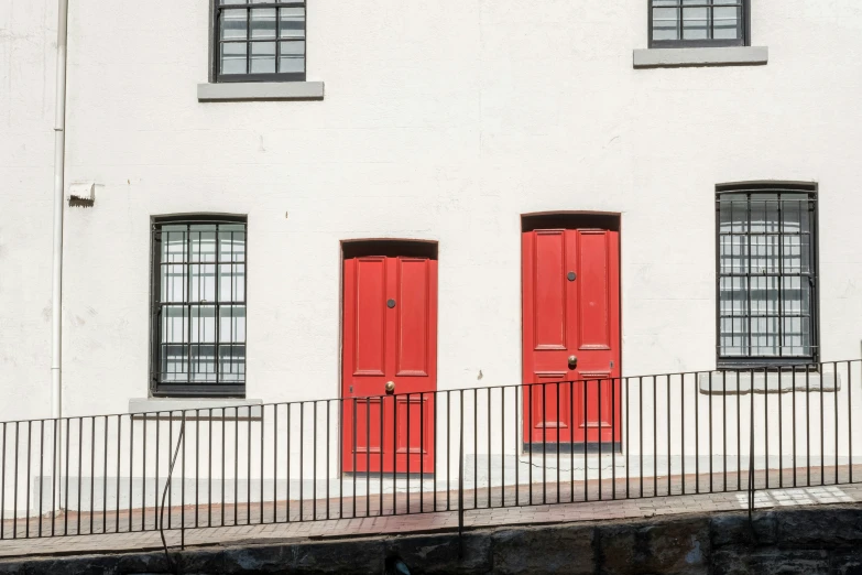 a red double doored house with two black windows