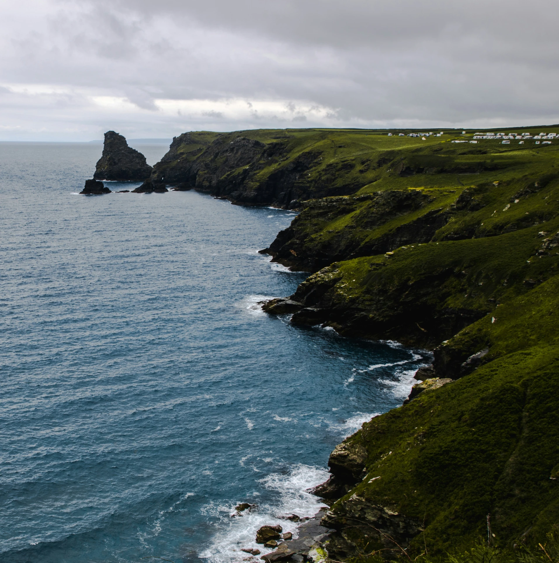 some very pretty water by some shore and grassy hills