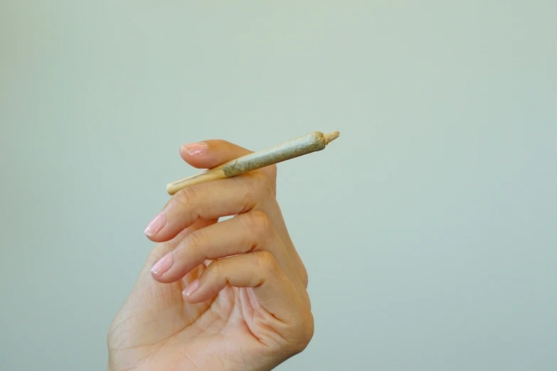 a woman is holding a cigarette in her left hand