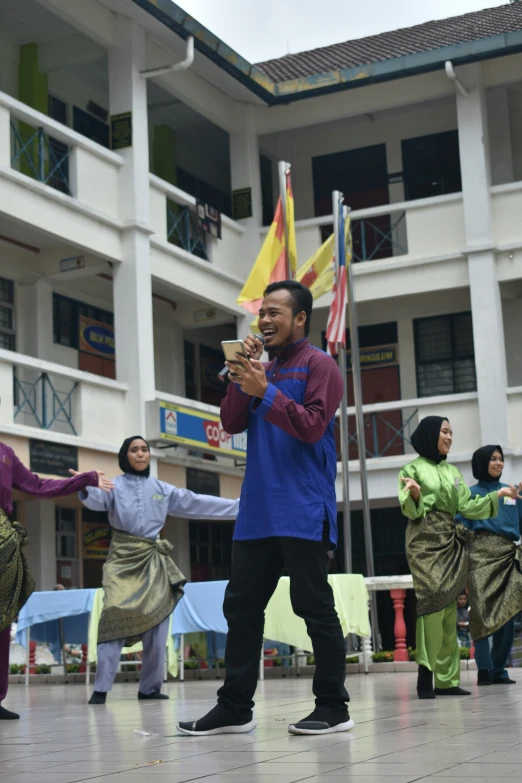 the man is standing in the middle of a group of people doing tricks