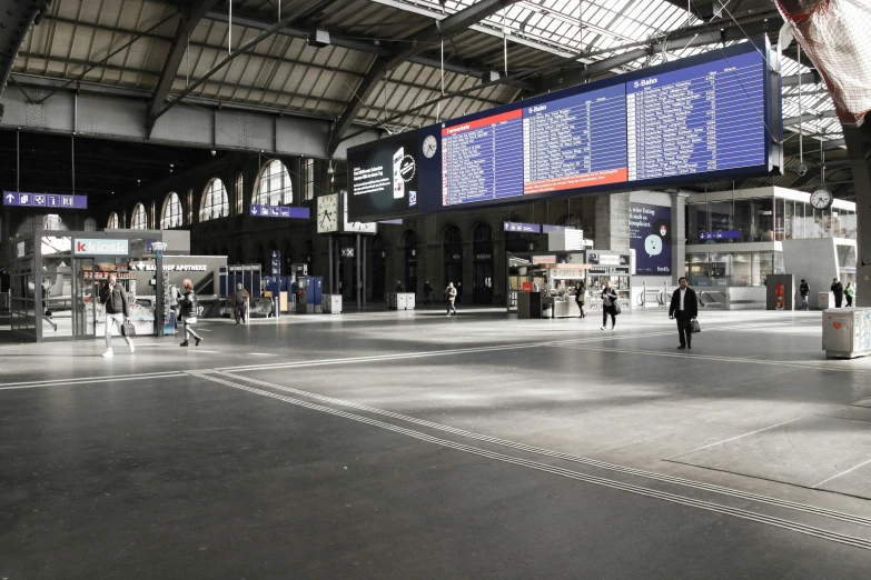 a covered train station with signs and people