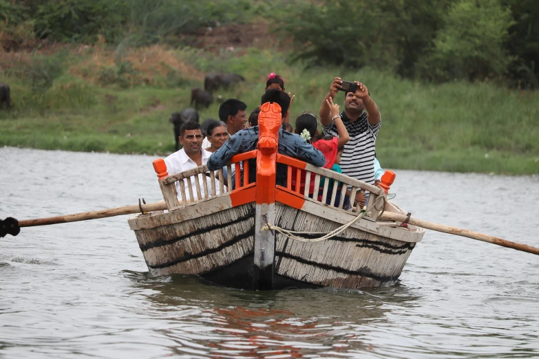 a boat full of people sailing in water with two poles