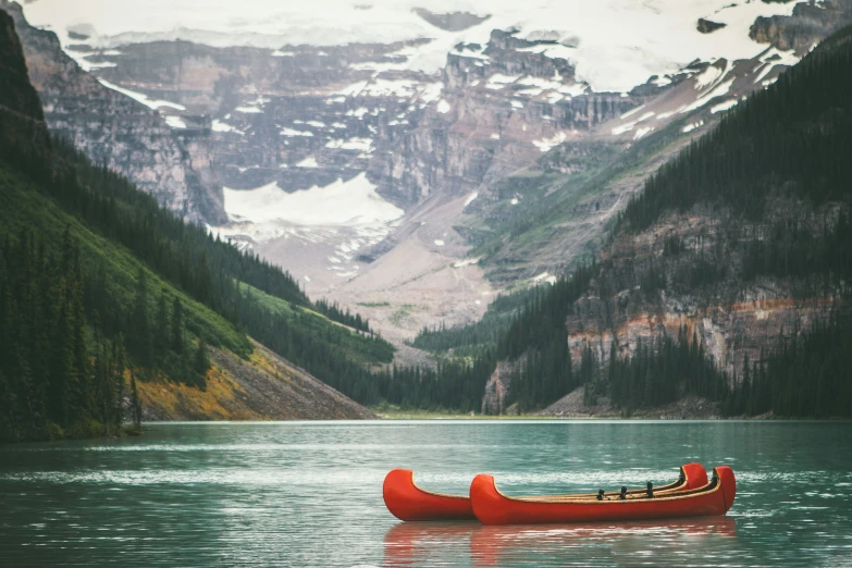 a canoe is sitting on a lake surrounded by trees