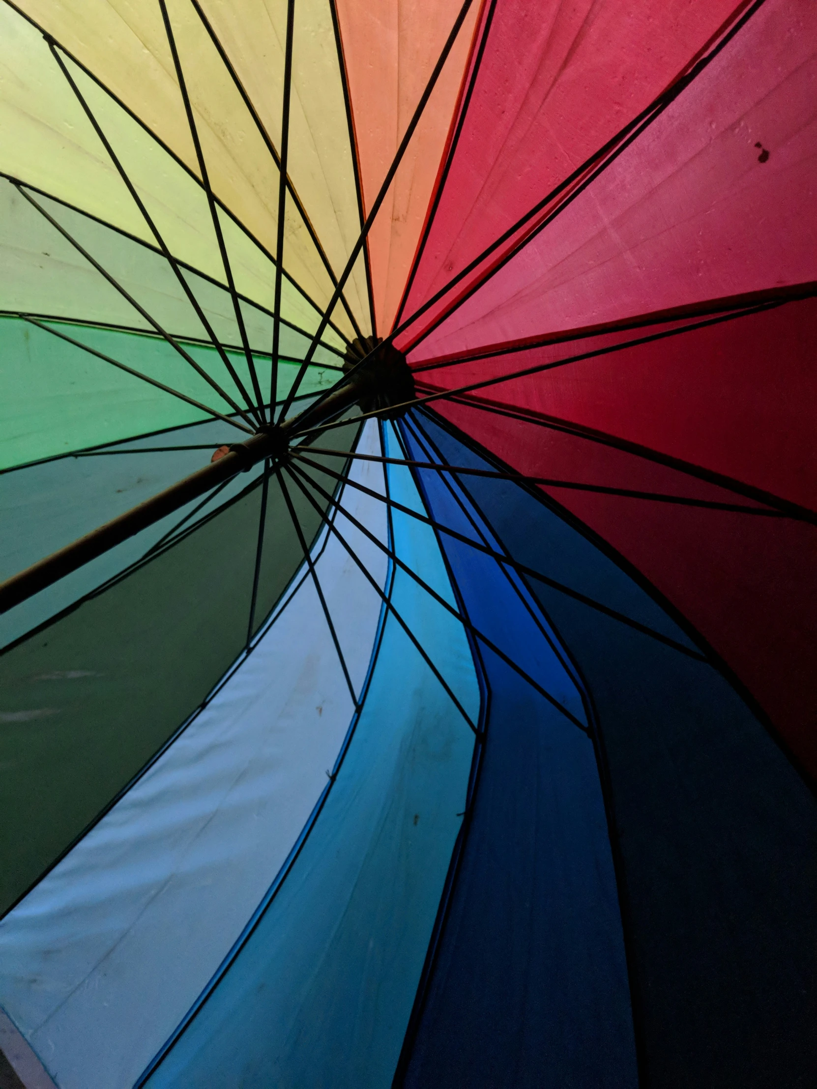 colorful open umbrella with black spokes and multi colored paper