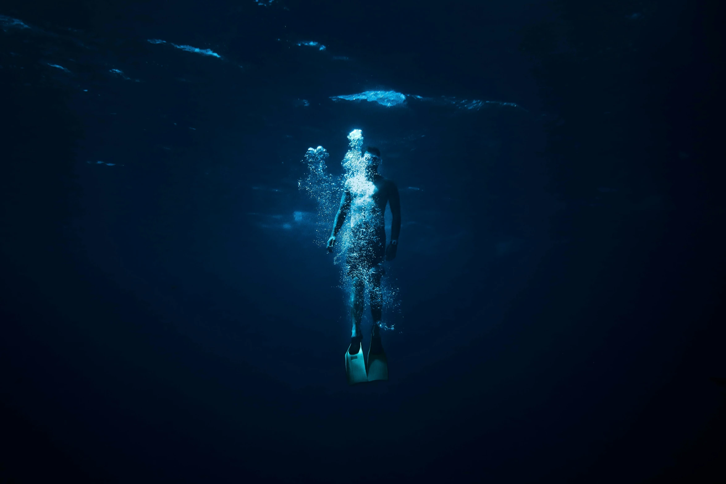 a female in a swim suit on a small surfboard in the deep blue water