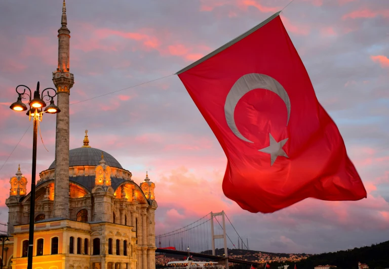 a turkish flag flying in front of a light pole