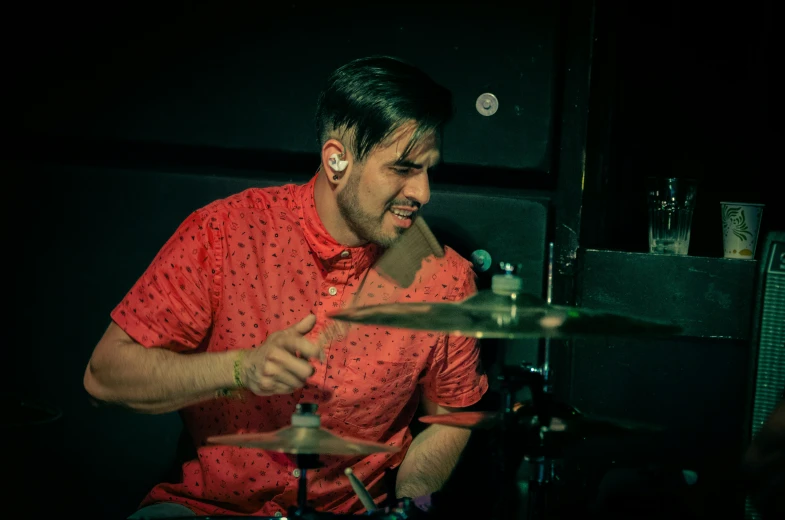 a man is playing drums in the dark