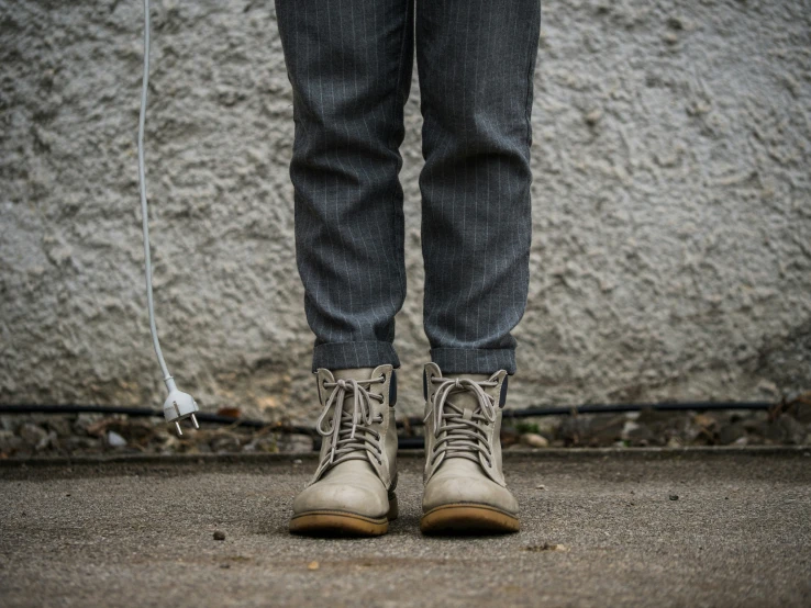 a person's shoes and the rope running across the pavement