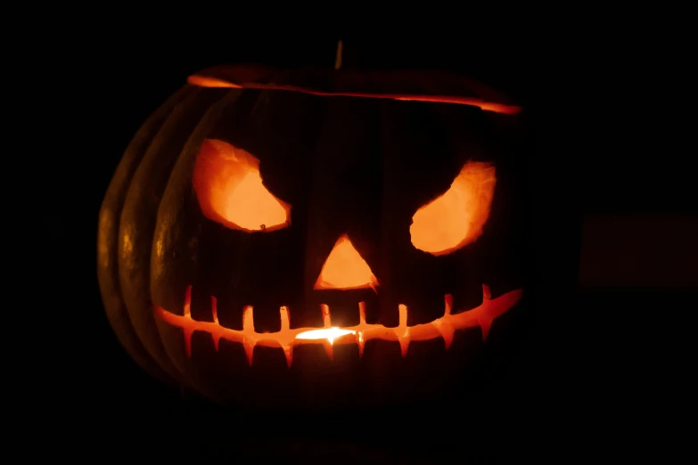 an evil pumpkin with its teeth glowing bright