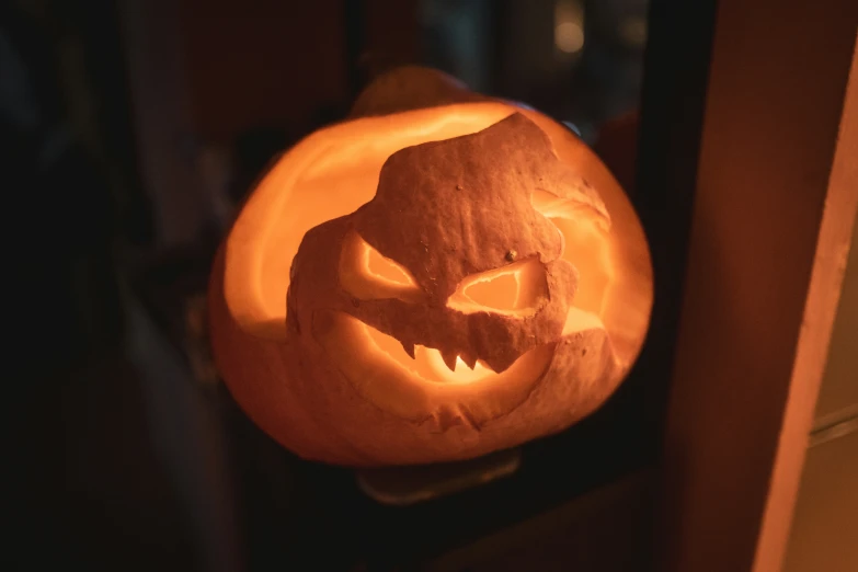 a lighted pumpkin sits on top of a table