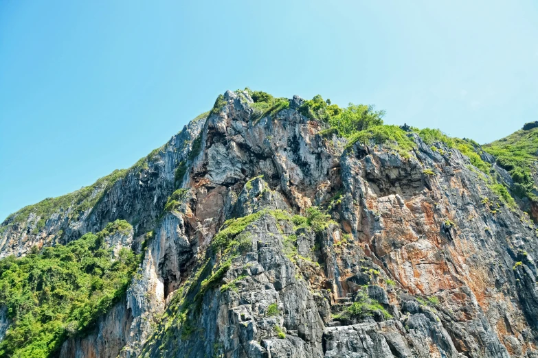 a large cliff side near a tree covered hillside