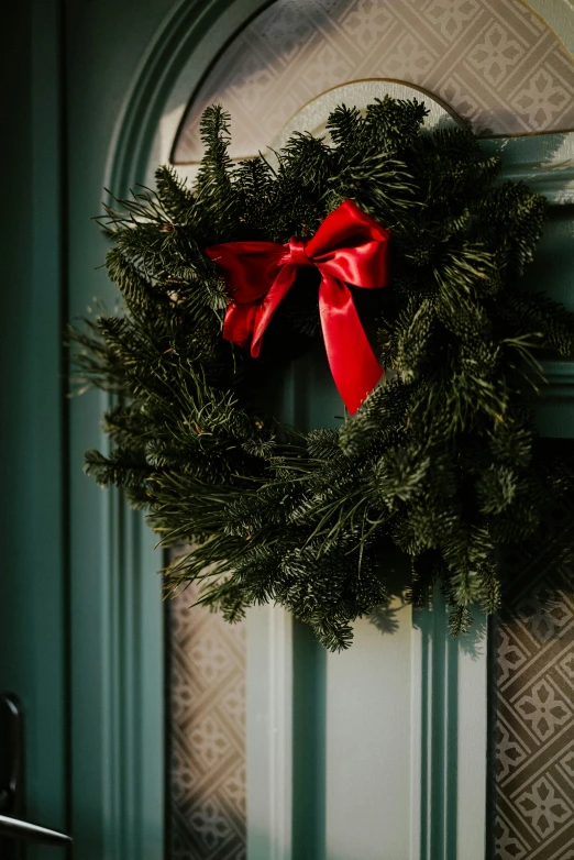 a christmas wreath is hung on the door handle