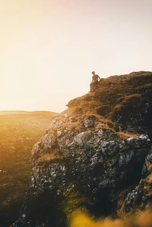 a man is sitting on top of the hill