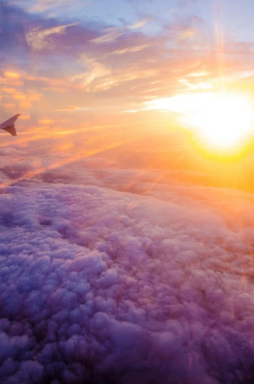 the sky above the clouds and a plane in the distance