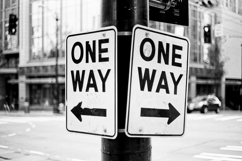 one way and one way street signs in the middle of the road