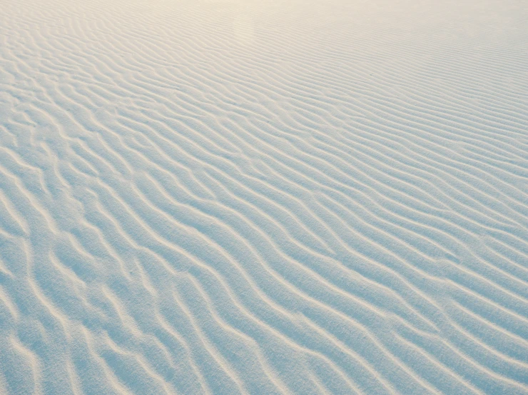 a small white sand dune with a clear sky