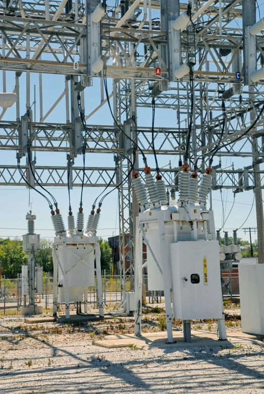 some power subs in a field by a fence