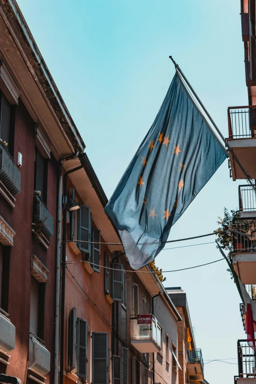 a street corner with several buildings and an upside down flag