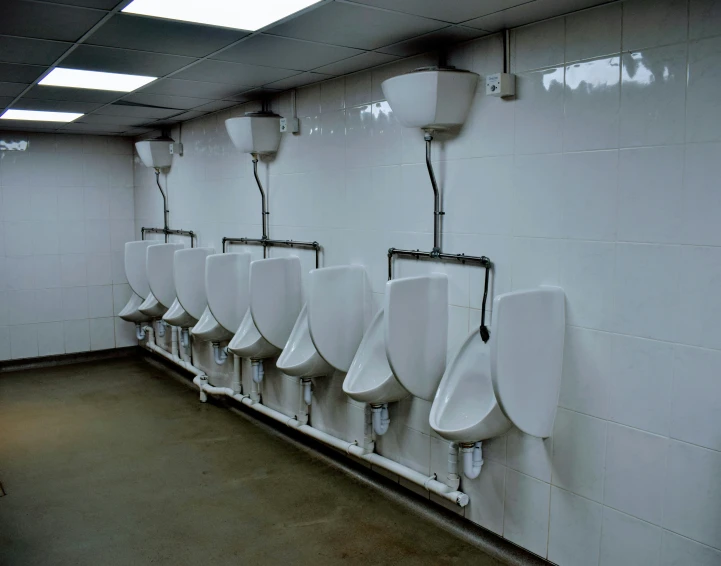 a public bathroom with urinals lined up on a wall