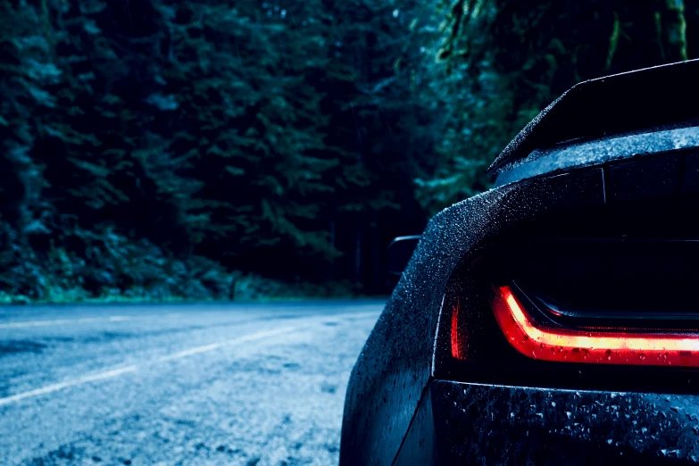 rear light on black sports car on wet road