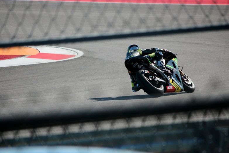 a motorcycle driver is riding down the track