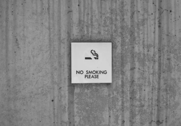 a no smoking sign on a wall with a white background