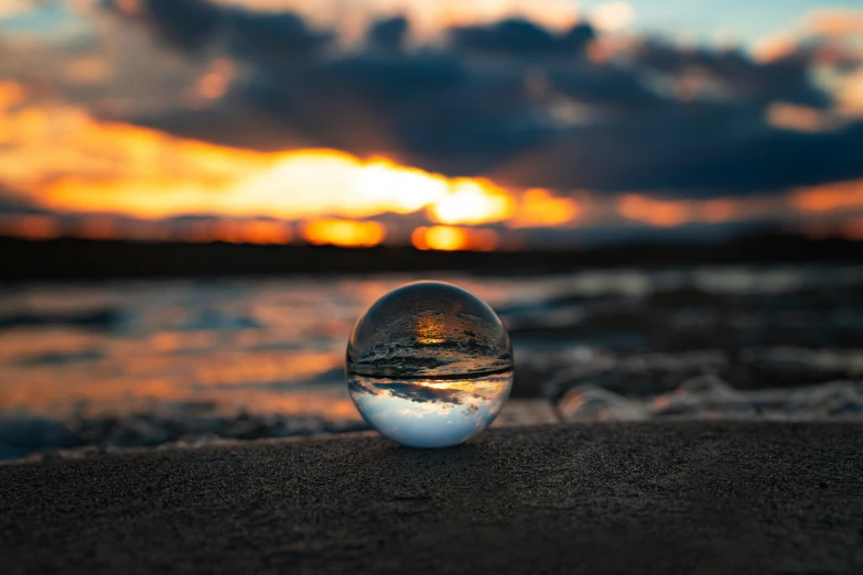 there is a glass ball sitting on the beach