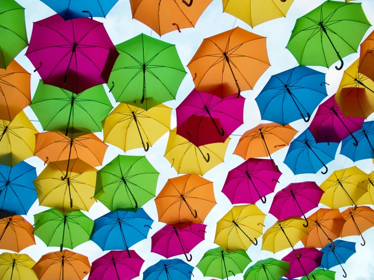 many colored umbrellas in an arrangement under a clear blue sky