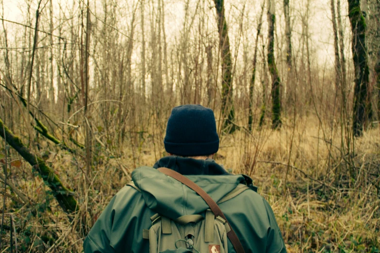 a man with backpack looking at the woods