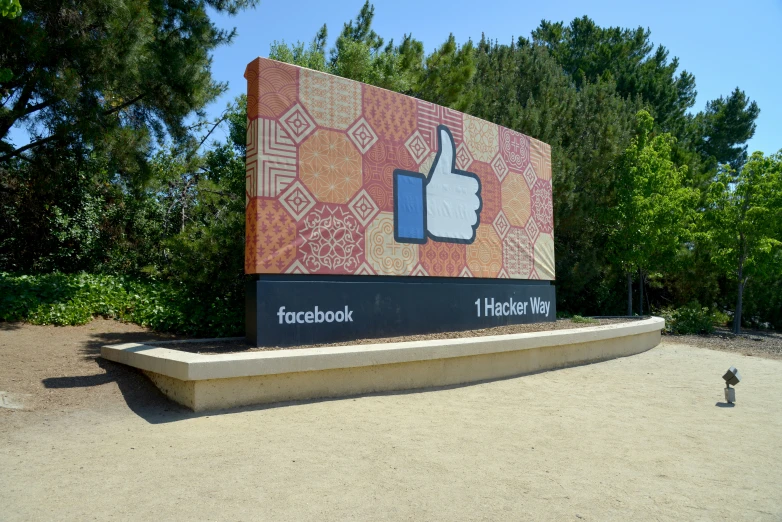 a building with an enormous sign on it in front of the facebook logo