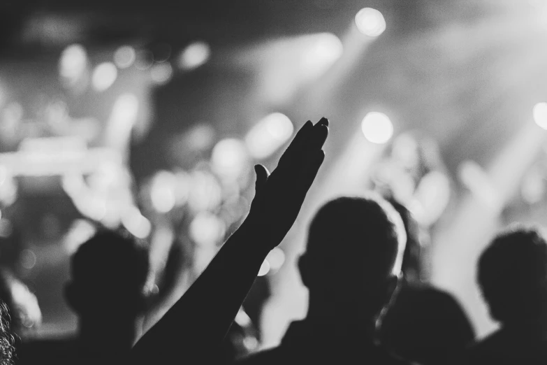 a crowd at a concert is raising their hands in the air