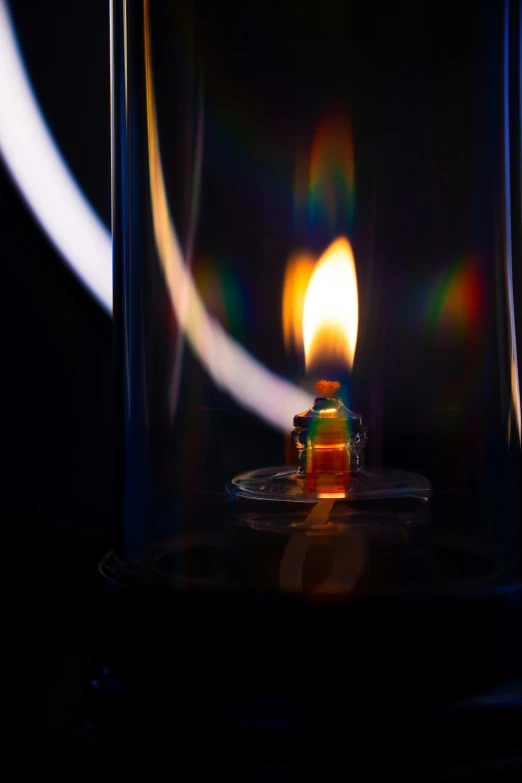 a lit candle in a glass container with light