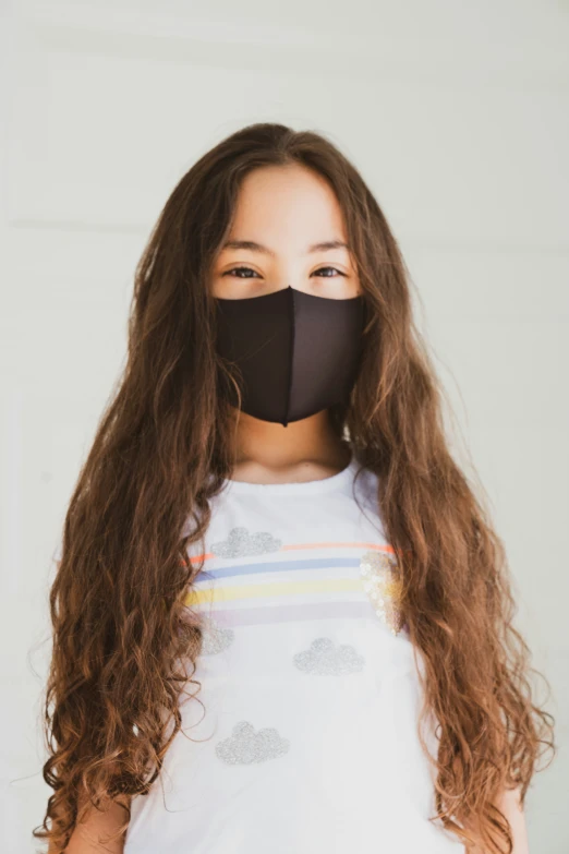 a woman wearing a black mask stands close to her face