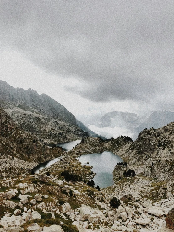 there is a lake in the middle of a rocky terrain