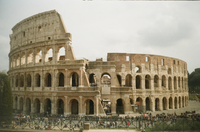 some people are standing near a very large stone structure