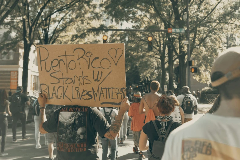 there is a group of people walking with a protest sign